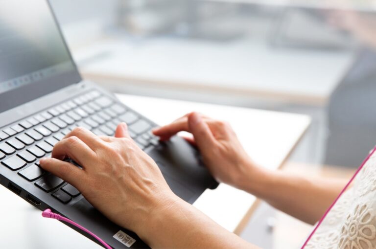 Person's hand using the keyboard of a laptop.