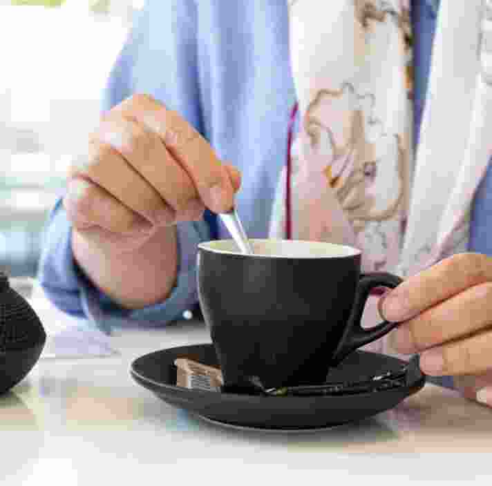 A person stirring a cup of tea.