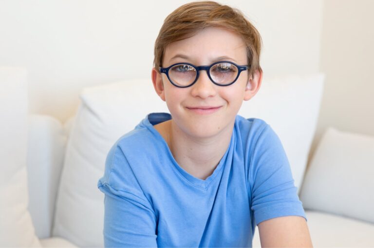 A young child looking at the camera smiling.