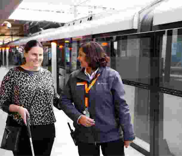 Nicole being guided by a station attendant on a train platform