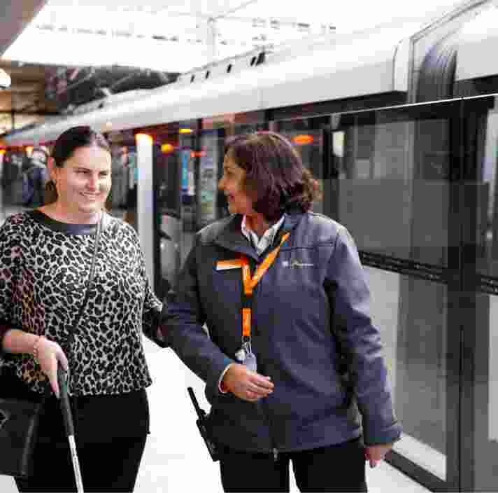 Nicole being guided by a station attendant on a train platform