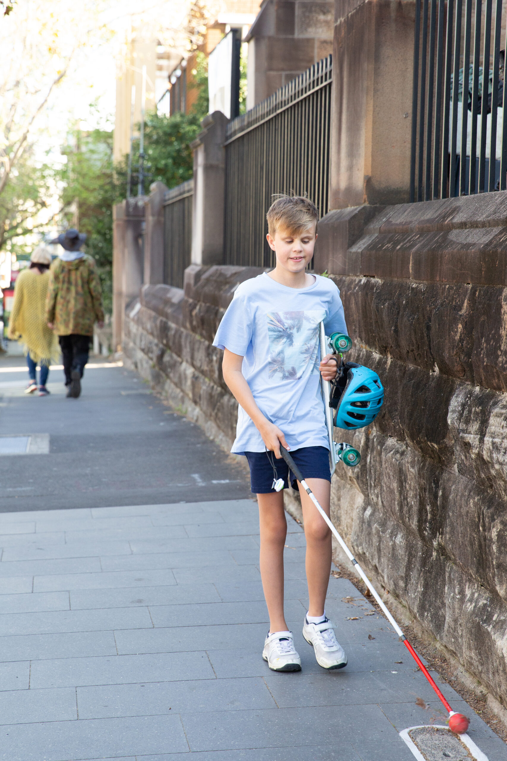A boy walking with his white cane
