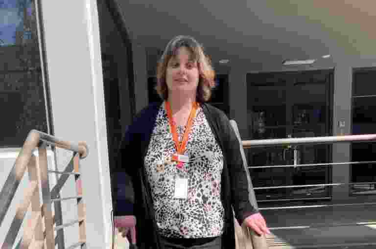 A person with a long cane walking down a set of stairs.