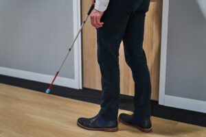 A person using a white can on a rubber floor strip.
