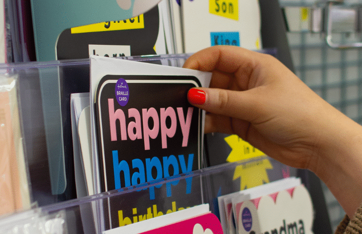 Image of someone reaching for an accessible Guide Dogs Hallmark card