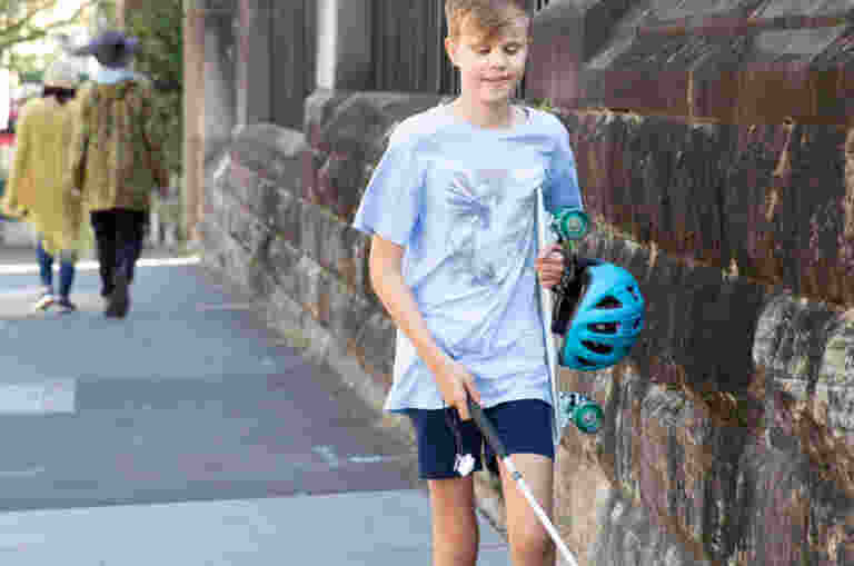 A boy walking with his white cane