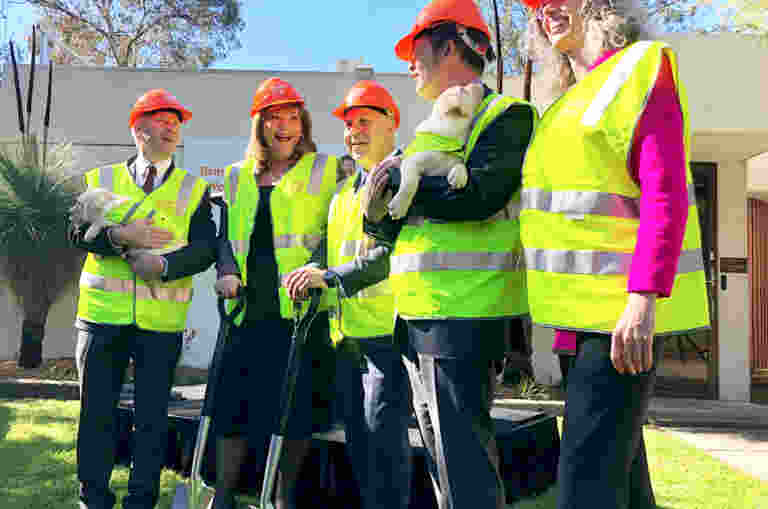 Iain Edwards, Karen Hayes, Tim Pallas MP, Luke Donnellan MP and Nina Taylor stand in High Vis vests with shovels in hand, outside Guide Dogs Victoria