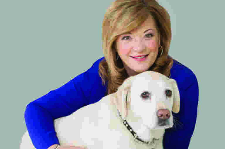 Karen Hayes has her arm around Williow, her ambassador dog.