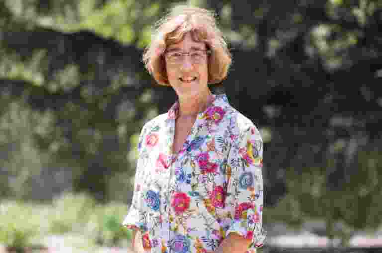 A person standing outside smiling at the camera.