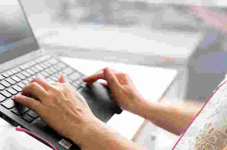 Person's hand using the keyboard of a laptop.