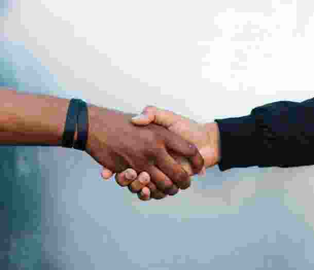 A close up image of two people shaking hands.