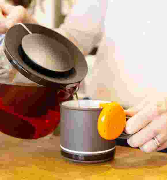 A close up shot of a person making a cup of tea.