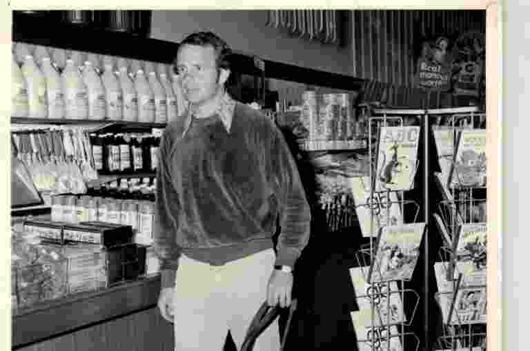 A black and white photo of John Gosling training a yellow Labrador
