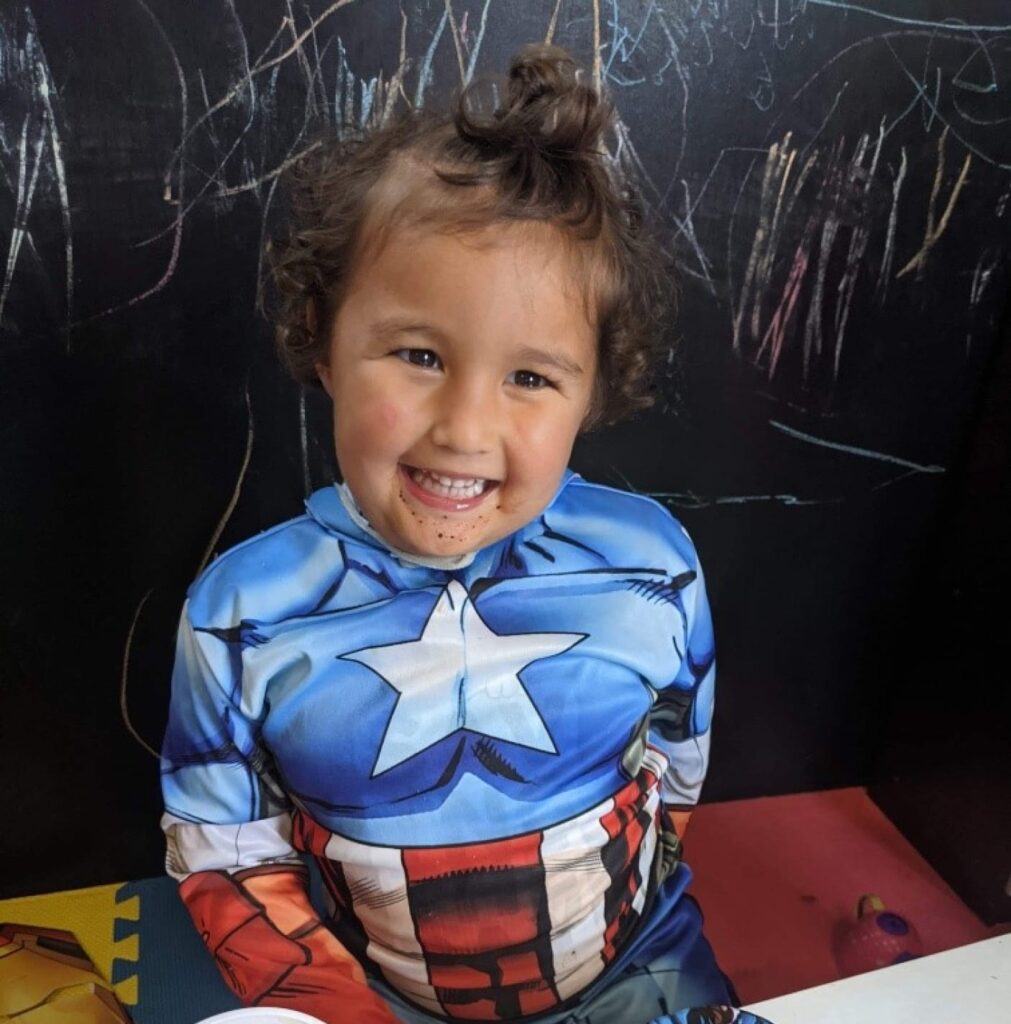Ezra smiling while wearing a Captain America outfit