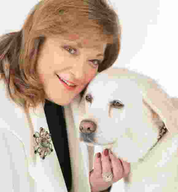A woman hugging a yellow Labrador.