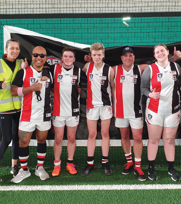 The St Kilda Blind Football club smiling and looking to camera.