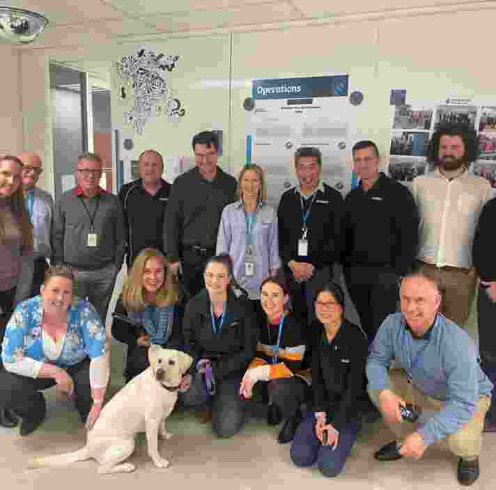 Piper during her AGIG visit, surrounded by the team