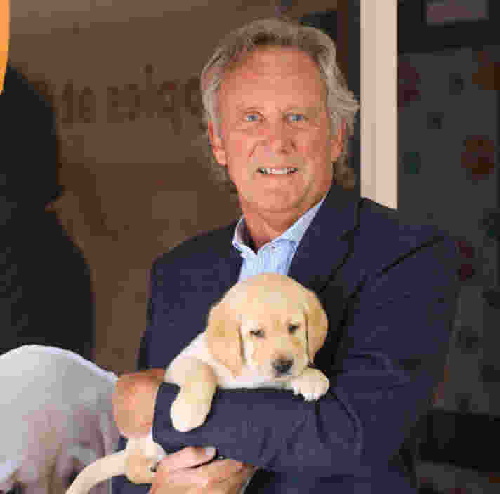 Dr. David Cochrane holding a yellow Labrador puppy