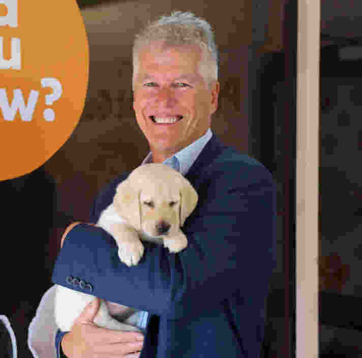 Nick Mescher holding a yellow Labrador puppy