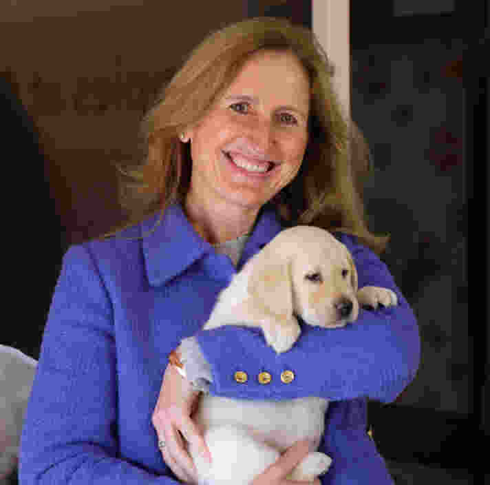 Melissa Dixon holding a yellow labrador puppy