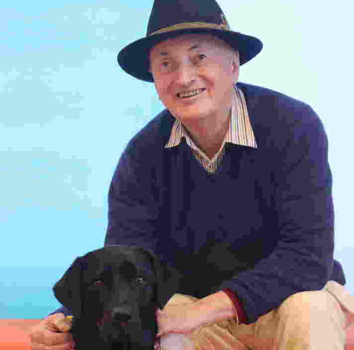 Cameron Algie sitting next to his Guide Dog