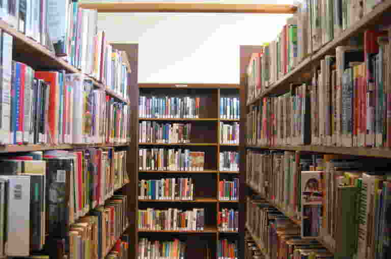 A hallway of bookshelves in a library.