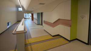 Yellow tactile floor bumps next to a wheelchair accessible ramp. 