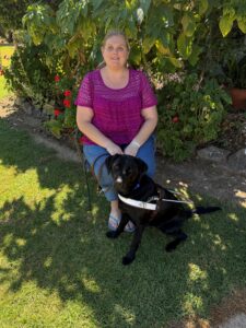 Tegan sitting outside her home with Ethel in harness by her feet.