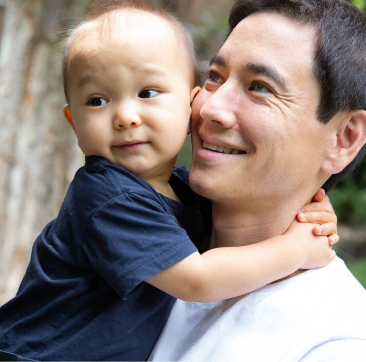 Child being held by his dad.