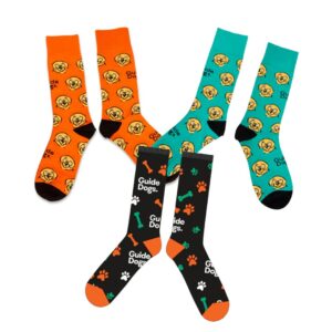 Orange and green socks covered with labrador face and Guide Dog logo pattern. Black socks with orange and green paw prints, bones and Guide Dogs logo pattern.