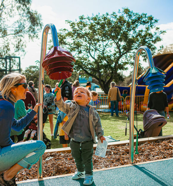 Children playing in playground with parents