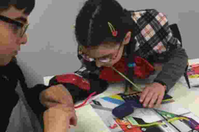 Two young clients, Jacinta and Liam, making tactile maps together