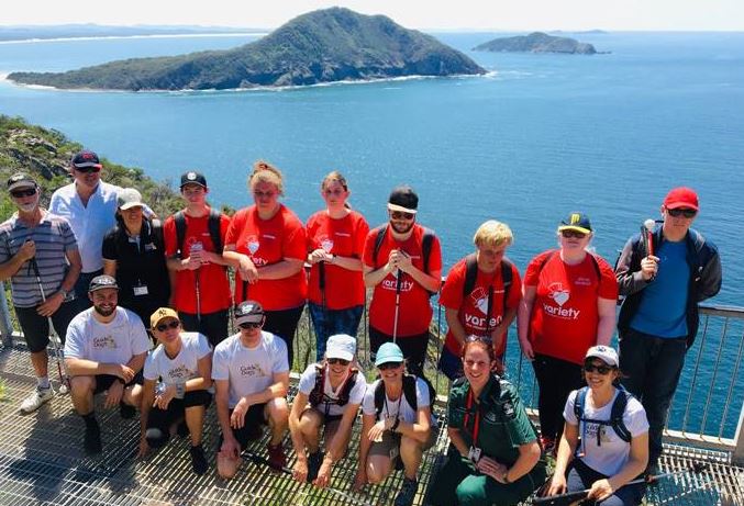 Seven young clients and Guide Dog staff at the top of Mt Tomaree