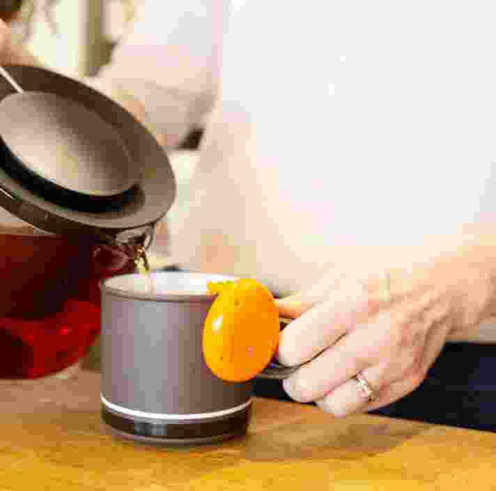 A close up shot of a person making a cup of tea.
