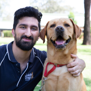 A man hugging a yellow Labrador.