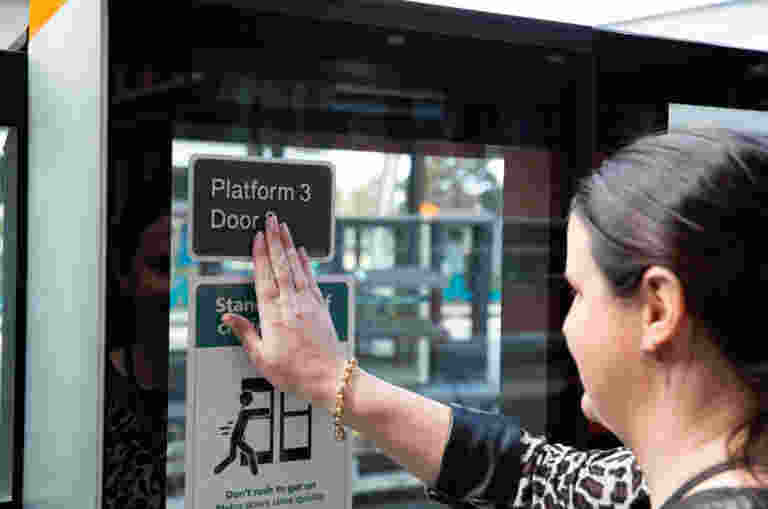 A person using Braille at a train station