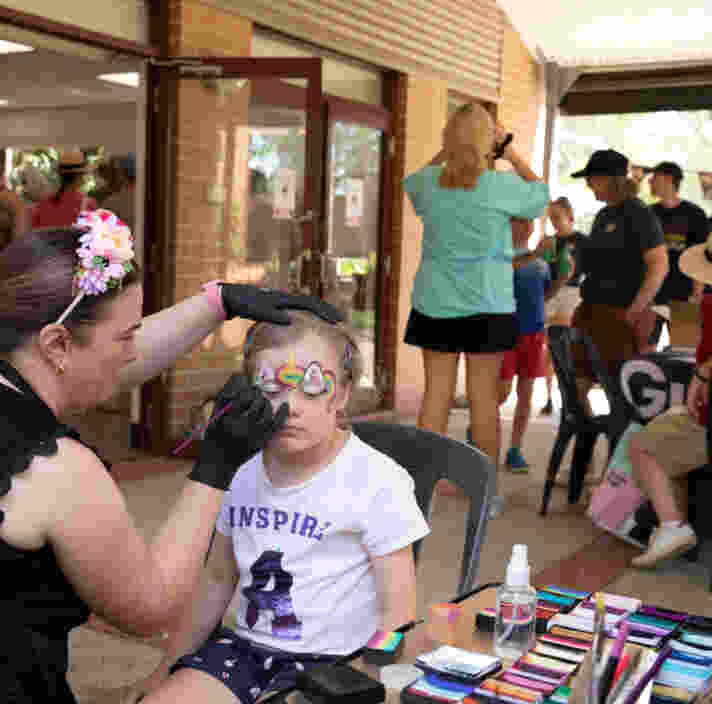 A child getting their face painted at an event