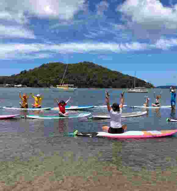A group of Clients doing Stand Up Paddleboarding in the water.