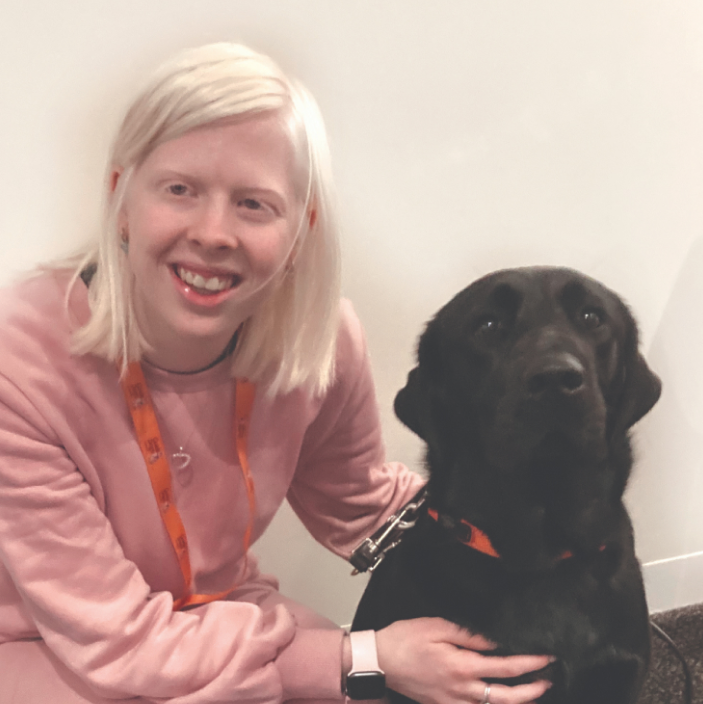 Lucy and Dottie, a black Labrador Guide Dog, sitting together