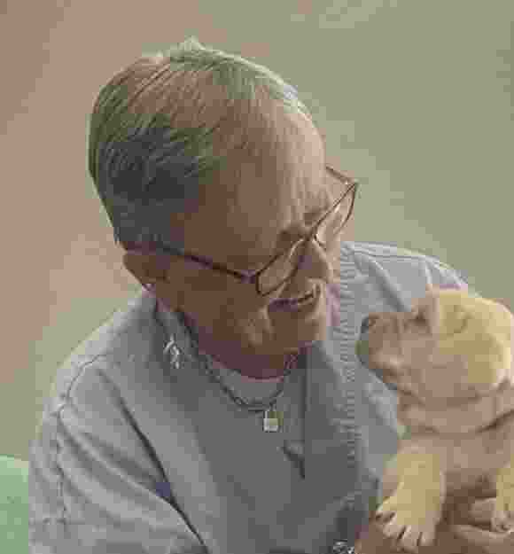 Sue holding a yellow Labrador puppy