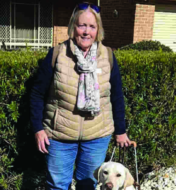Angela and yellow Guide Dog Jolie in harness.