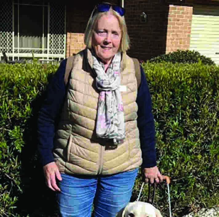 Angela and yellow Guide Dog Jolie in harness.