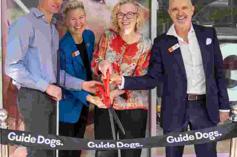 Four people about to cut the ribbon at the Guide Dogs office in Newcastle