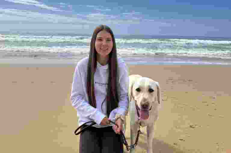 Karlee and Isla sitting together at the beach.