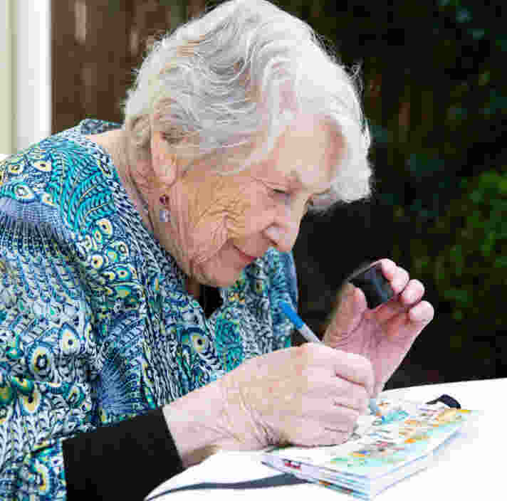 A person using a magnifing device to read a book.