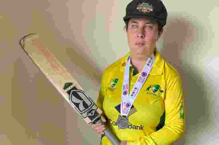 Jennifer Parry standing in cricket gear holding a bat.