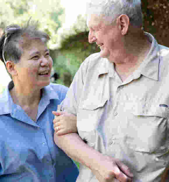 Two people walking arm in arm.