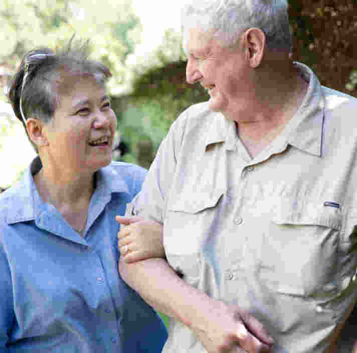 Two people walking arm in arm.