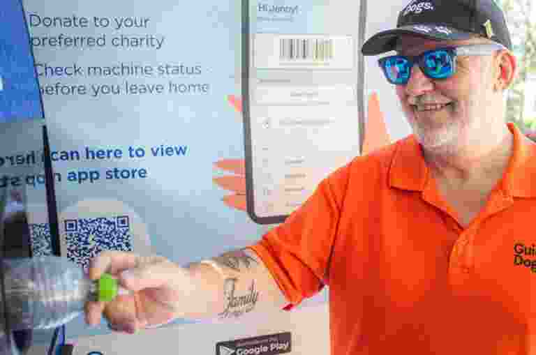 Client Connection Specialist Tony putting a bottle into a Kiosk.