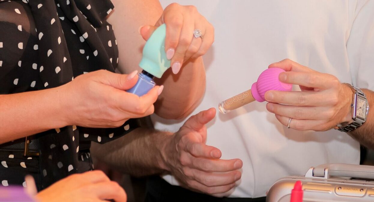 Two people holding products at the beauty summit.